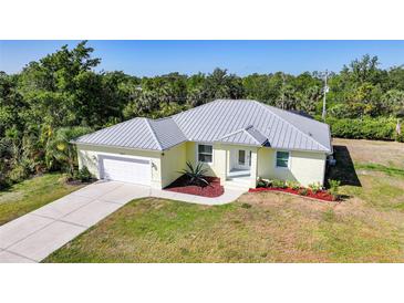 Charming single-story home with a well-maintained lawn, attached garage, and decorative landscaping at 2957 Montgomery Dr, Port Charlotte, FL 33981
