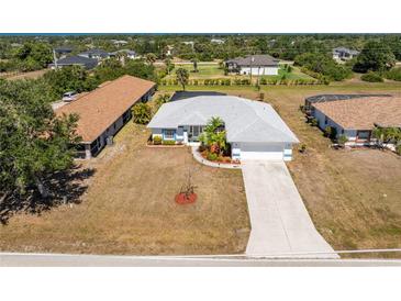 Lovely single-story home featuring mature landscaping, a two-car garage, and a long driveway at 311 Boundary Blvd, Rotonda West, FL 33947