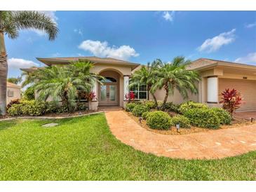 Charming single-Gathering home featuring lush landscaping, a terracotta walkway, and a well-manicured lawn at 8180 Burwell Cir, Port Charlotte, FL 33981