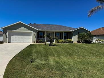 Charming single-story home with a well-manicured lawn, landscaped garden, and a two-car garage at 174 Broadmoor Ln, Rotonda West, FL 33947