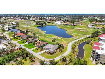 Beautiful aerial view of a golf course community, with a tranquil lake and lush landscaping at 585 Coral Creek Dr, Placida, FL 33946