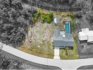 Beautiful home boasts a private pool, surrounded by lush greenery, and located on an oversized lot at 7180 Quarry St, Englewood, FL 34224