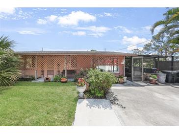Charming single-story home with lattice accents, a well-kept lawn, and lovely landscaping at 857 Palmetto St, Englewood, FL 34223