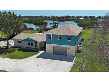 Waterfront home with a two-car garage and well-maintained lawn at 1605 Manor Rd, Englewood, FL 34223