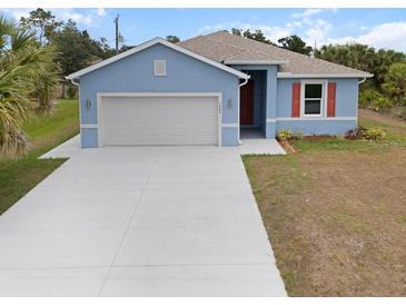 Charming single-story home with a two-car garage, light blue paint, and fresh landscaping at 1664 Karluk St, North Port, FL 34287