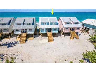 Aerial view showcasing charming beachfront homes on stilts, offering stunning ocean views at 301 S Gulf Blvd # 3, Placida, FL 33946