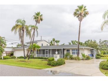 Charming single-story home featuring a lush landscaped yard and tall palm trees providing a tropical feel at 407 Park S Blvd, Venice, FL 34285