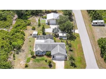 A nice aerial view of a single-Gathering home featuring a spacious yard, pool and two storage buildings at 4510 Burns Ter, Port Charlotte, FL 33981