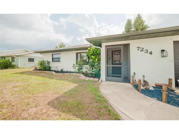 Charming single-story home featuring well-maintained landscaping, a screen door, and a welcoming walkway at 7234 Mamouth St, Englewood, FL 34224