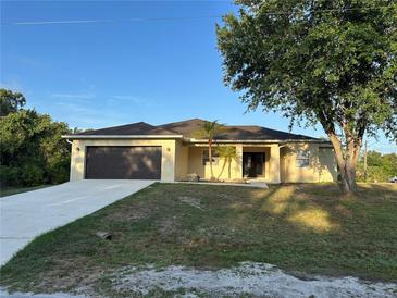Charming single-story home with a two car garage, tropical landscaping, and well manicured lawn at 15417 Hanley Ct, Port Charlotte, FL 33953