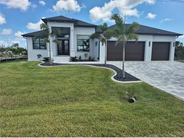 Well-manicured lawn of a home featuring a three-car garage, dark trim windows, and decorative palm trees at 10454 Atenia St, Port Charlotte, FL 33981