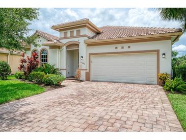 Charming single-story home featuring a brick driveway, two-car garage, and beautifully landscaped front yard at 13282 Scrub Jay Ct, Port Charlotte, FL 33953