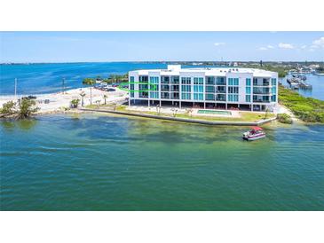 Waterfront condo building with a pool and boat access on a clear day with blue skies and turquoise water at 1375 Beach Rd # 201, Englewood, FL 34223