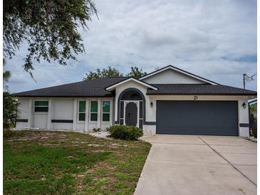 Charming single-story home with a well-manicured front yard and attached two-car garage at 21 Sportsman Way, Rotonda West, FL 33947