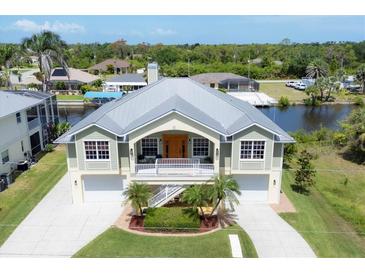Stunning elevated home features a metal roof, two-car garage, and beautiful landscaping and water access at 4219 Spire St, Port Charlotte, FL 33981