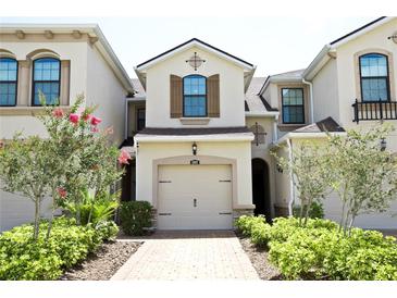 Charming townhouse featuring a one-car garage and well-manicured front yard with flowering bushes at 5009 Skyview Ln, Bradenton, FL 34211