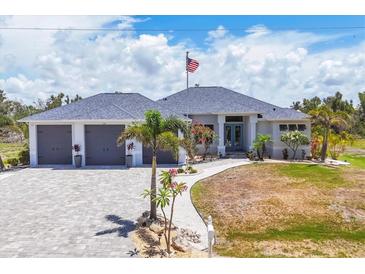 Beautiful home featuring a three car garage, paver driveway, and manicured landscaping at 530 Spaniards Rd, Placida, FL 33946