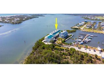 Waterfront condos with marina access; white exteriors, turquoise roofs, lush surroundings at 8005 Bay Pointe Dr, Englewood, FL 34224