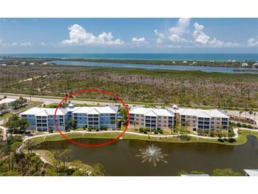 Condo community with beautiful landscaping, lake with fountain, and ocean views from upper floors at 8405 Placida Rd # 406, Placida, FL 33946