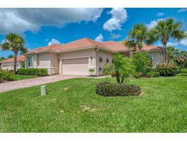 Charming single-story home with tile roof, attached garage, and lush tropical landscaping at 13051 Creekside Ln, Port Charlotte, FL 33953