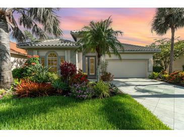 Charming home featuring lush landscaping, a tile roof, and a well-manicured lawn at 13376 Golf Pointe Dr, Port Charlotte, FL 33953