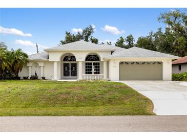 Charming single Gathering home featuring a manicured lawn and arched entryways to enhance curb appeal at 18112 Windswept Av, Port Charlotte, FL 33948