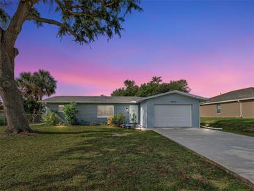 Charming single story home boasts brick accents, a manicured lawn, and an attached two car garage at 21519 Fairway Ave, Port Charlotte, FL 33952