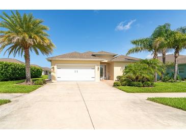Inviting single-story home featuring lush landscaping, a two-car garage, and a well-manicured lawn at 267 Talquin Ct, Englewood, FL 34223