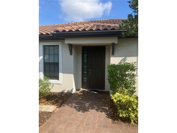 Inviting front door entrance featuring a brick pathway and beautiful landscaping at 10258 Morning Mist Ln, Sarasota, FL 34241
