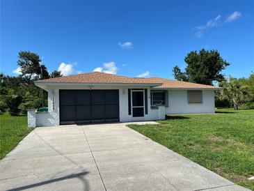 Charming single-story home featuring a well-maintained lawn and a convenient attached garage at 11029 Vanessa Ave, Englewood, FL 34224