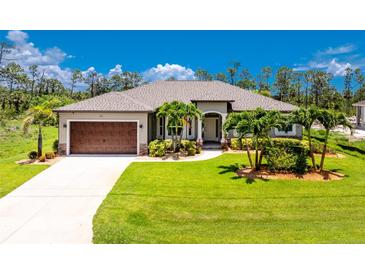 Beautiful single-story home featuring a manicured lawn and a large, attached two-car garage at 1119 Boundary Blvd, Rotonda West, FL 33947