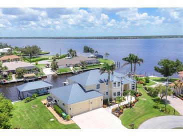 Expansive waterfront home boasts lush landscaping, a private boat dock, and stunning river views at 12438 Prather Ave, Port Charlotte, FL 33981
