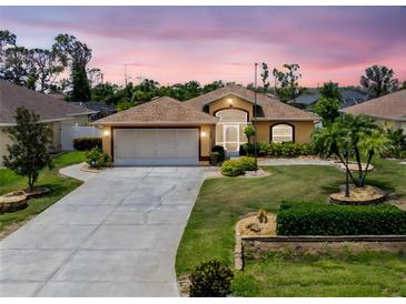Charming home featuring a well-manicured lawn, neutral paint, and a two-car garage at 127 Jennifer Dr, Rotonda West, FL 33947