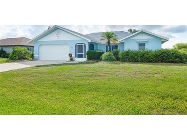 Charming blue single-story home featuring a well-manicured lawn and tropical landscaping at 15 Bunker Pl, Rotonda West, FL 33947