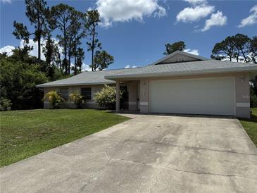 Charming single-story home with a well-maintained lawn and a two-car garage at 2473 Woodyglen St, Port Charlotte, FL 33948