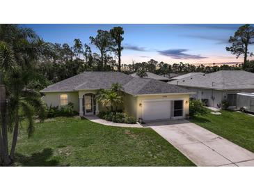 Charming single-story home with a well-manicured lawn, mature trees, and a two-car garage at 2588 Westberry Ter, North Port, FL 34286