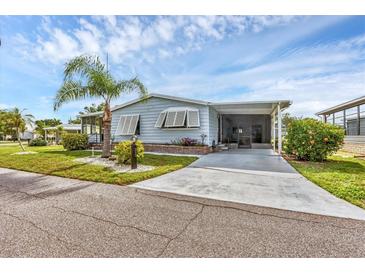 Charming single-story home featuring a well-maintained lawn, palm tree, and covered carport at 742 Portwine Ct # 17, Englewood, FL 34223