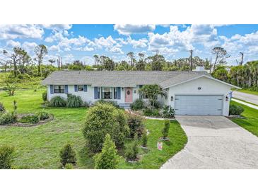 Charming single-story home featuring a manicured lawn and an inviting pink front door at 7690 Castleberry Ter, Englewood, FL 34224