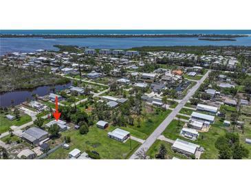 High aerial view of the neighborhood and surrounding waterways, dotted with lush trees at 8224 Pinetree Ln, Englewood, FL 34224