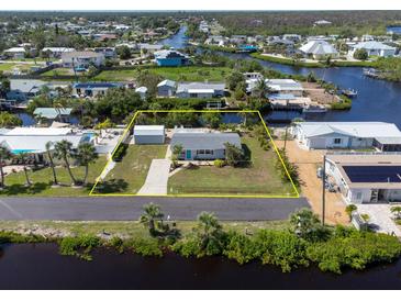 Aerial view of waterfront property with lush landscaping, and canal access surrounded by other homes at 1060 Haste Ln, Englewood, FL 34223