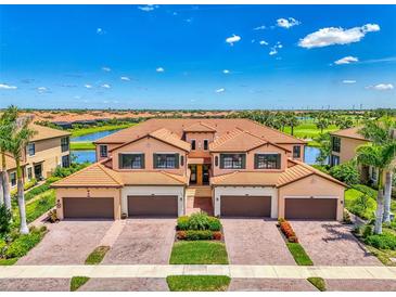 Beautiful Mediterranean-style villa with a clay tile roof, paver driveway, and lush landscaping at 10788 Tarflower Dr # 201, Venice, FL 34293