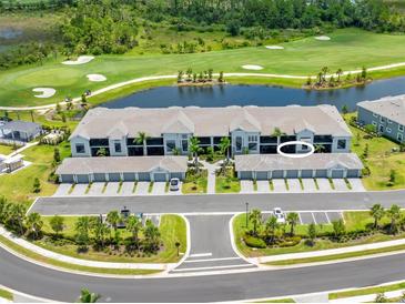 Beautiful aerial view of condo building overlooking golf course, pond and garages with palm trees at 12470 Wellen Golf St # 107, Venice, FL 34293