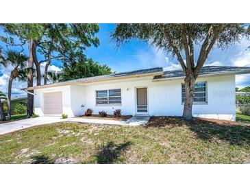 Charming single-story home featuring a well-maintained lawn and mature trees at 1785 Morning Dove Ln, Englewood, FL 34224