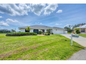 Charming single-story home with lush green lawn and well-manicured landscaping at 2106 Damascus Ln, Punta Gorda, FL 33983