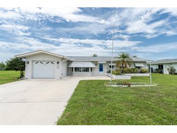 Charming single-story home with an attached garage, well-manicured lawn, and a delightful landscaped flowerbed at 39 Caddy Rd, Rotonda West, FL 33947