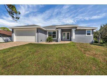Charming single-story home with a gray exterior, well-manicured lawn and two-car garage at 5781 Elton Rd, Venice, FL 34293