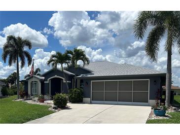 Charming single-story home with a well-manicured lawn, mature palm trees, and a two-car garage at 7130 Scarlet Sage Ct, Punta Gorda, FL 33955