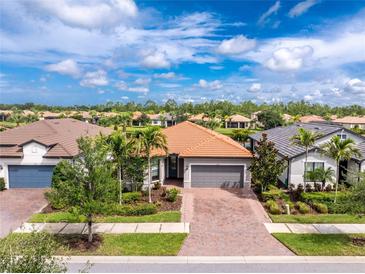 Beautiful single-Gathering home with a well-manicured lawn, beautiful plants, and a neutral color scheme at 1530 Hyssop Loop, North Port, FL 34289