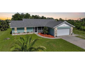 Charming single-story home with well-manicured lawn, stone accents, and a two-car garage at 7453 Spinnaker Blvd, Englewood, FL 34224
