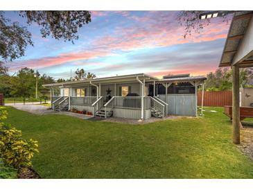 Charming single-story home with a large front porch and well-manicured lawn at 12511 Walton Ave, New Port Richey, FL 34654